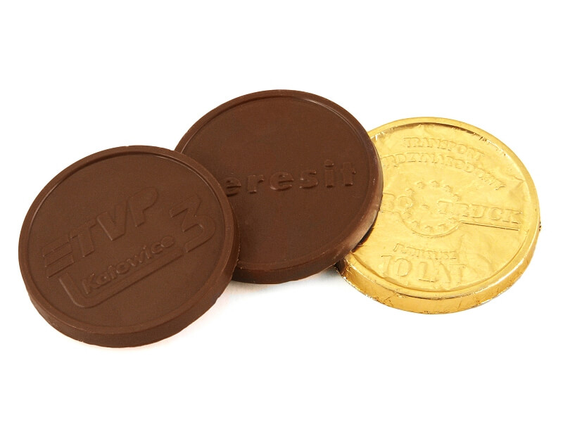 Mały czekoladowy medal z prostym motywem graficznym, zapakowany w złotą folię aluminiową